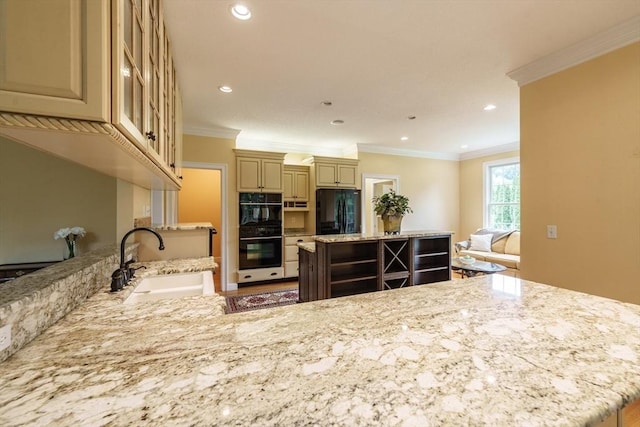9 Windsor Ln, East Longmeadow, MA 01028 - kitchen featuring black appliances, cream cabinetry, a kitchen island, light stone counters, and ornamental molding