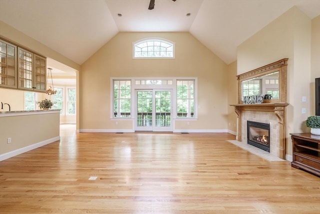 9 Windsor Ln, East Longmeadow, MA 01028 - unfurnished living room featuring high vaulted ceiling, a tile fireplace, light wood-type flooring, and a ceiling fan