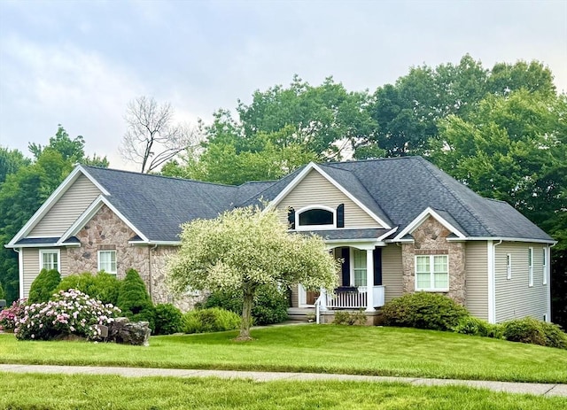 9 Windsor Ln, East Longmeadow, MA 01028 - view of front of house with stone siding, covered porch, a front yard, and roof with shingles