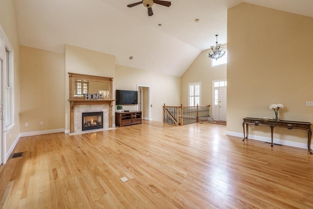 9 Windsor Ln, East Longmeadow, MA 01028 - living area with light wood-style floors, a ceiling fan, high vaulted ceiling, a fireplace, and a chandelier