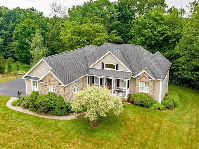 9 Windsor Ln, East Longmeadow, MA 01028 - view of front of home with stone siding, covered porch, a front lawn, and a shingled roof