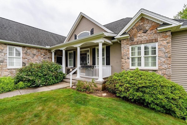 9 Windsor Ln, East Longmeadow, MA 01028 - view of front of property featuring stone siding, covered porch, a front lawn, and roof with shingles