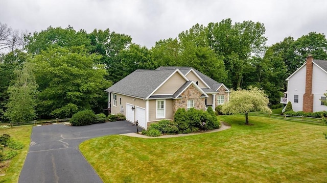 9 Windsor Ln, East Longmeadow, MA 01028 - view of front facade featuring asphalt driveway, a garage, view of wooded area, and stone siding