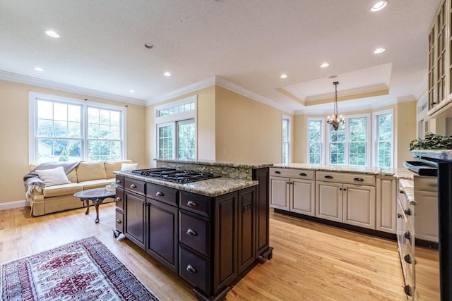9 Windsor Ln, East Longmeadow, MA 01028 - kitchen with crown molding, light wood finished floors, gas stovetop, a chandelier, and light stone counters