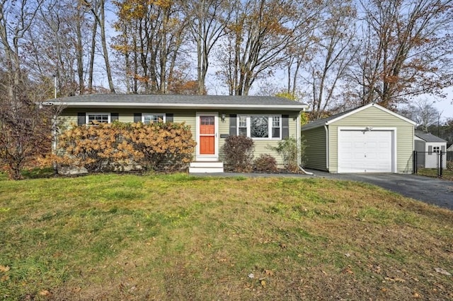 ranch-style home featuring an outbuilding, driveway, entry steps, a detached garage, and a front yard