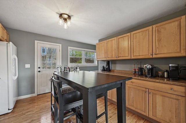 kitchen with baseboards, light wood-type flooring, and freestanding refrigerator