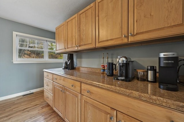 bar featuring visible vents, light wood-style floors, and baseboards