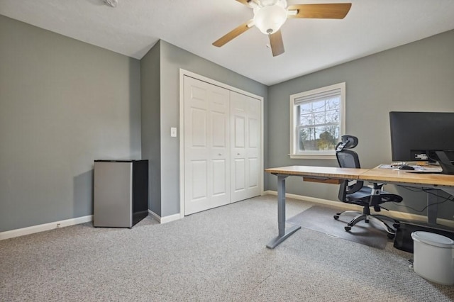 carpeted office space with baseboards and ceiling fan