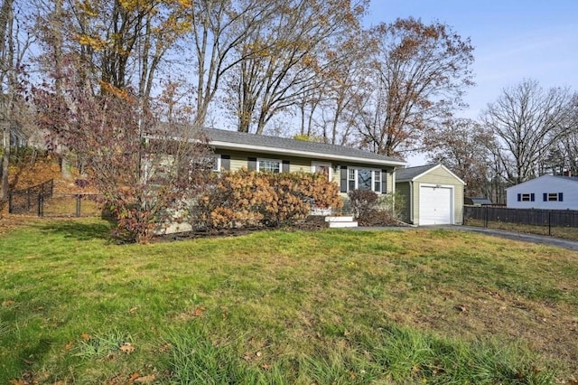 single story home featuring a front lawn, fence, an outbuilding, and driveway