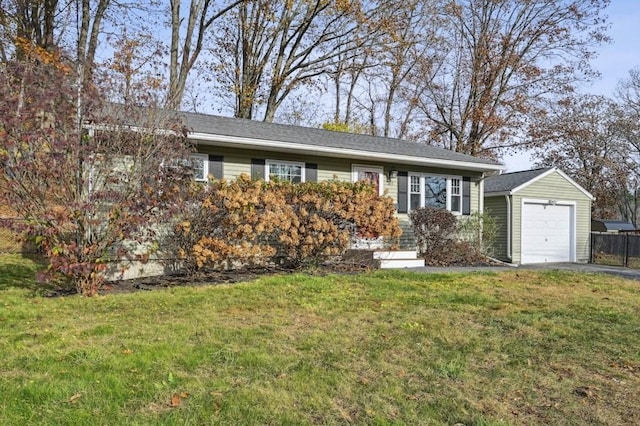 ranch-style home with an outbuilding, a garage, driveway, and a front yard