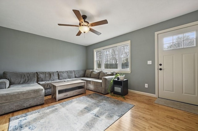 living area featuring ceiling fan, baseboards, and wood finished floors