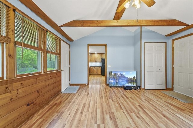 unfurnished living room with light wood-style floors, baseboards, and a ceiling fan