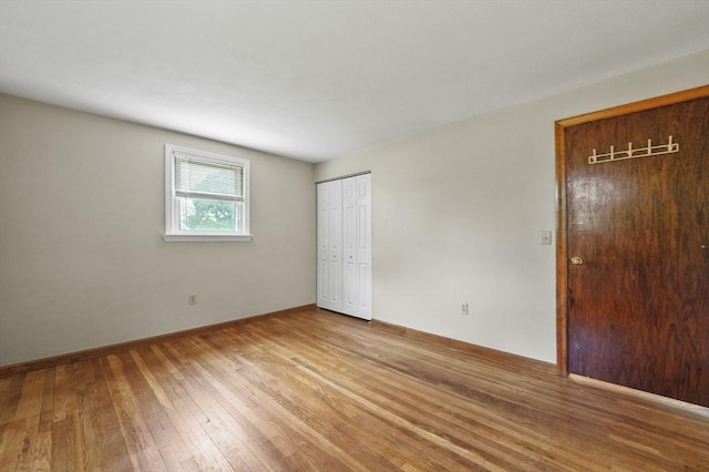 unfurnished bedroom with wood-type flooring and baseboards