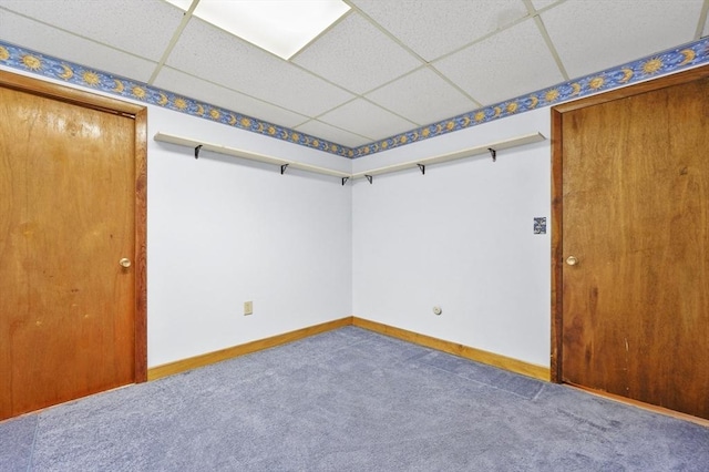 empty room with a drop ceiling, carpet flooring, and baseboards
