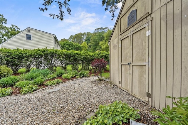 view of yard with an outdoor structure, a shed, and fence