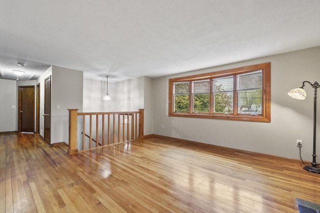 unfurnished room featuring hardwood / wood-style floors and baseboards