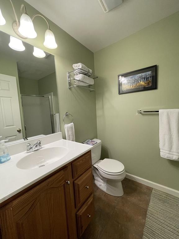 9201 Mountainside Dr Unit 9201, Hancock, MA 01237 - full bathroom featuring a shower stall, vanity, toilet, baseboards, and tile patterned flooring