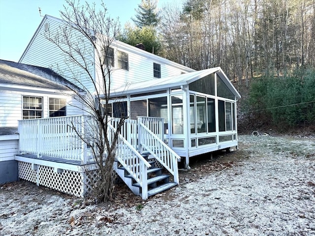 back of house with a wooden deck and a sunroom