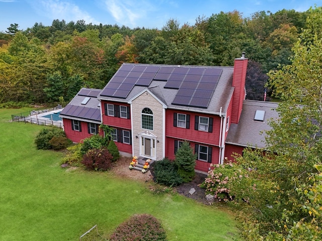 view of front of house with solar panels and a front lawn