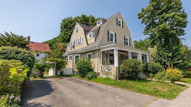 view of front of home featuring a gambrel roof and a porch