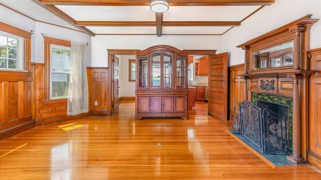 interior space with beam ceiling, wainscoting, and light wood-type flooring