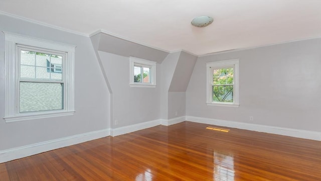 bonus room featuring plenty of natural light, wood finished floors, and baseboards