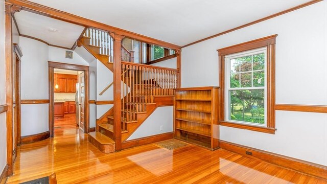 stairs featuring crown molding, wood finished floors, and baseboards