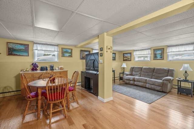 dining space featuring plenty of natural light, light wood-type flooring, and a drop ceiling