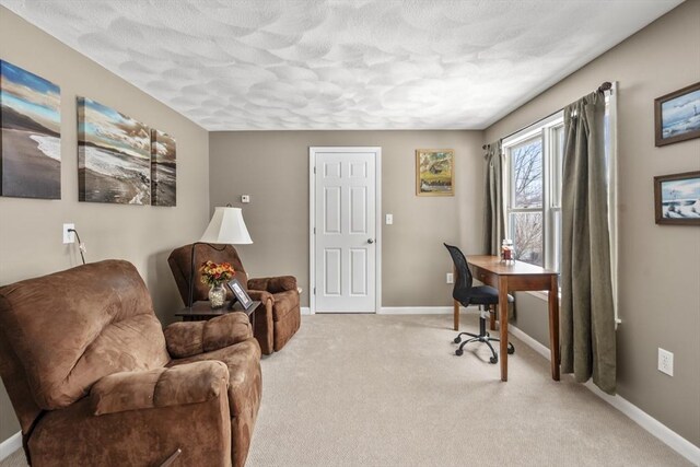 office featuring a textured ceiling, baseboards, and light carpet