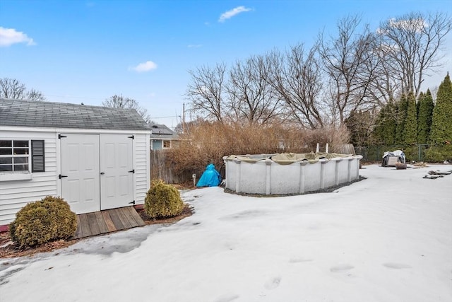 view of yard with a covered pool, a shed, an outdoor structure, and fence