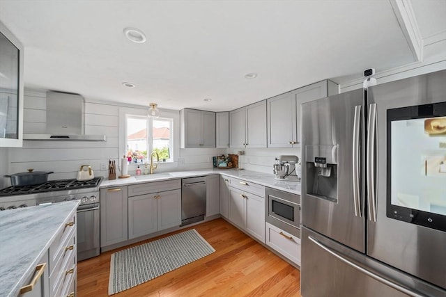 16 Squanto Rd, Weymouth, MA 02191 - kitchen featuring appliances with stainless steel finishes, wall chimney exhaust hood, gray cabinetry, light wood-style floors, and light stone counters