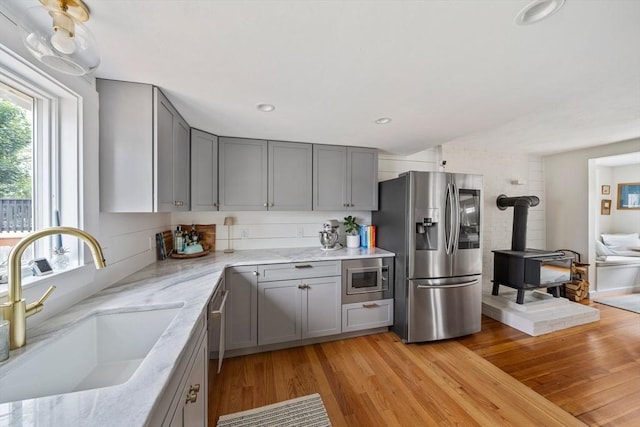 16 Squanto Rd, Weymouth, MA 02191 - kitchen featuring stainless steel appliances, gray cabinetry, a wood stove, light wood-style floors, and recessed lighting