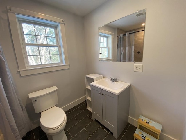 bathroom with toilet, vanity, tile patterned flooring, and walk in shower