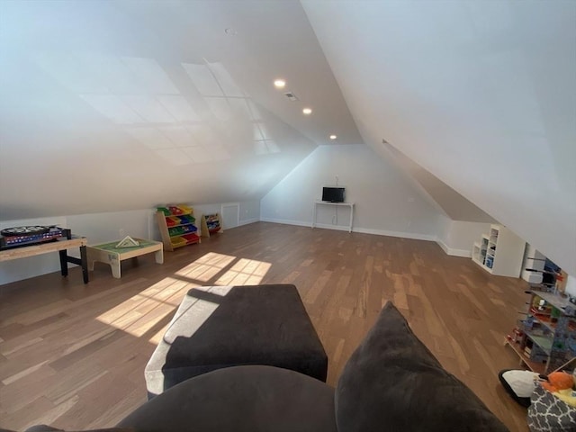 additional living space featuring lofted ceiling and hardwood / wood-style flooring