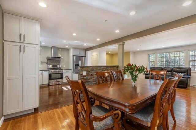 dining area with recessed lighting, light wood-style flooring, and ornate columns