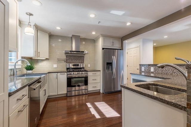 kitchen with a sink, wall chimney range hood, dark wood-style flooring, and stainless steel appliances