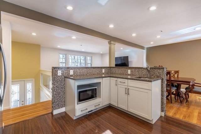 kitchen featuring a sink, dark stone countertops, dark wood-style floors, white cabinetry, and recessed lighting