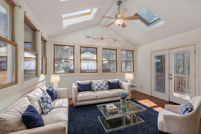 sunroom / solarium with lofted ceiling with skylight, a healthy amount of sunlight, french doors, and ceiling fan