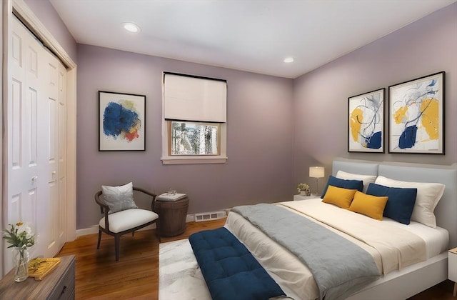 bedroom with wood finished floors, visible vents, baseboards, recessed lighting, and a closet