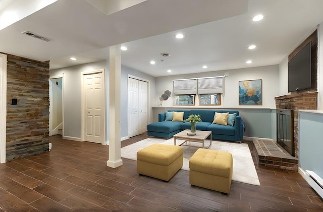 living room with stairway, visible vents, wood finish floors, recessed lighting, and a brick fireplace