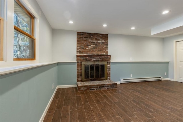 unfurnished living room featuring baseboard heating, recessed lighting, a fireplace, and wood finished floors