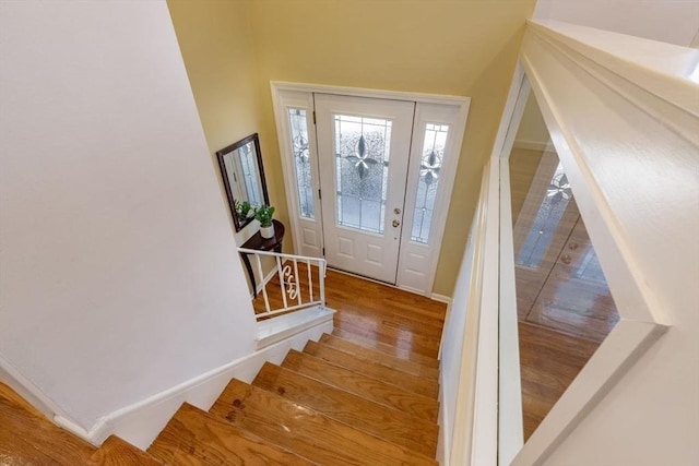 entrance foyer featuring stairway, wood finished floors, and baseboards