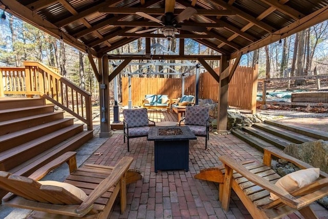 view of patio with an outdoor living space with a fire pit, a gazebo, and fence