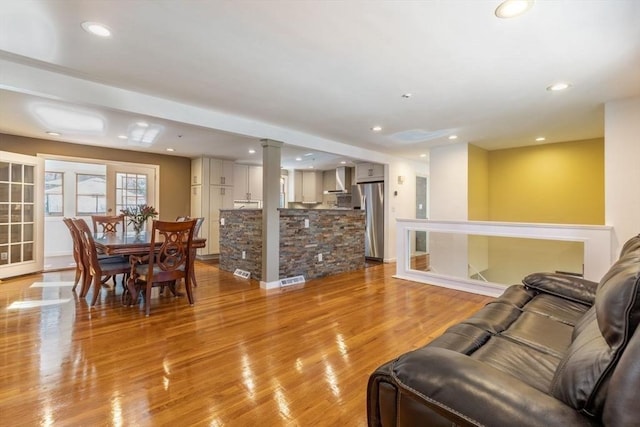 living area featuring light wood-style flooring, recessed lighting, visible vents, and french doors