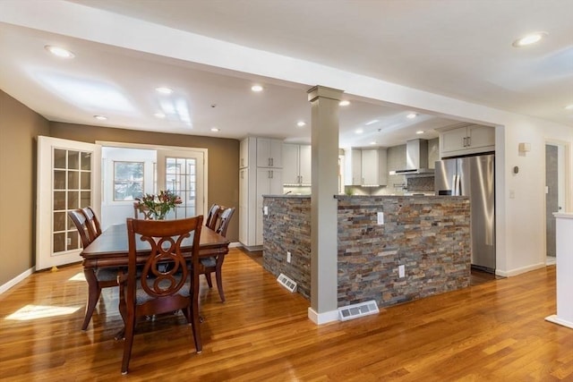 dining area with visible vents, baseboards, and wood finished floors