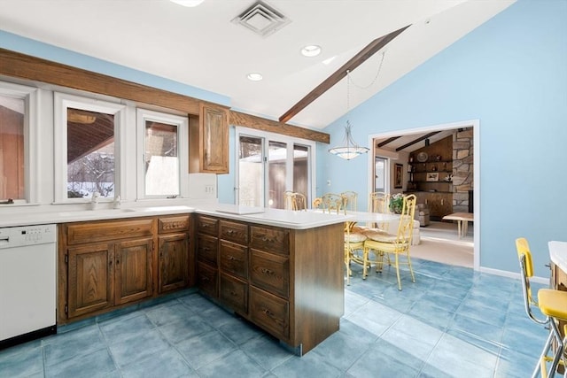 kitchen with sink, decorative light fixtures, vaulted ceiling, white dishwasher, and kitchen peninsula