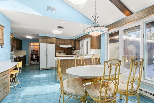 dining space featuring a baseboard radiator and vaulted ceiling with beams