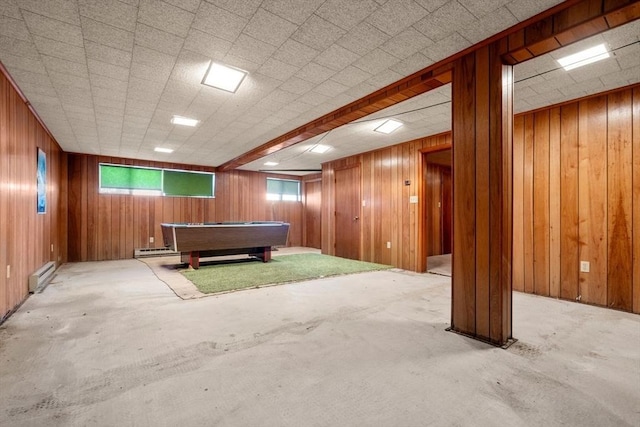 game room featuring a baseboard heating unit and wood walls