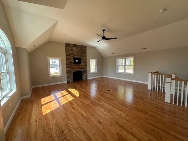 unfurnished living room featuring vaulted ceiling, wood finished floors, baseboards, and ceiling fan