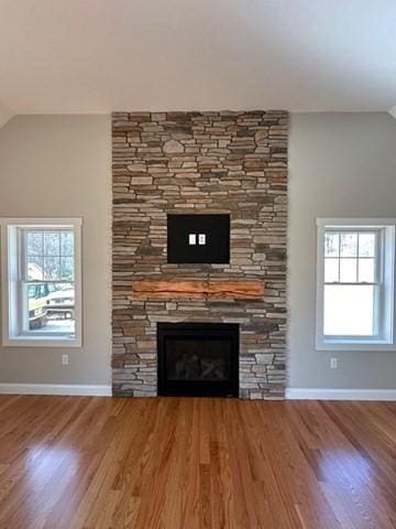 room details featuring a fireplace, wood finished floors, and baseboards